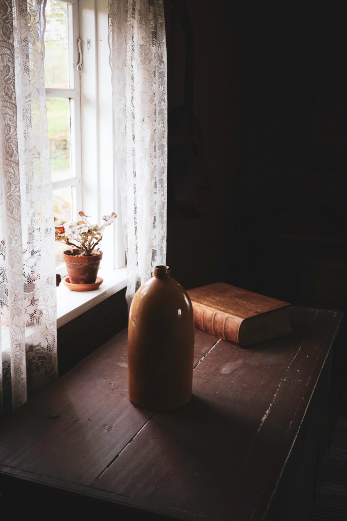 A Vase on a table with a book